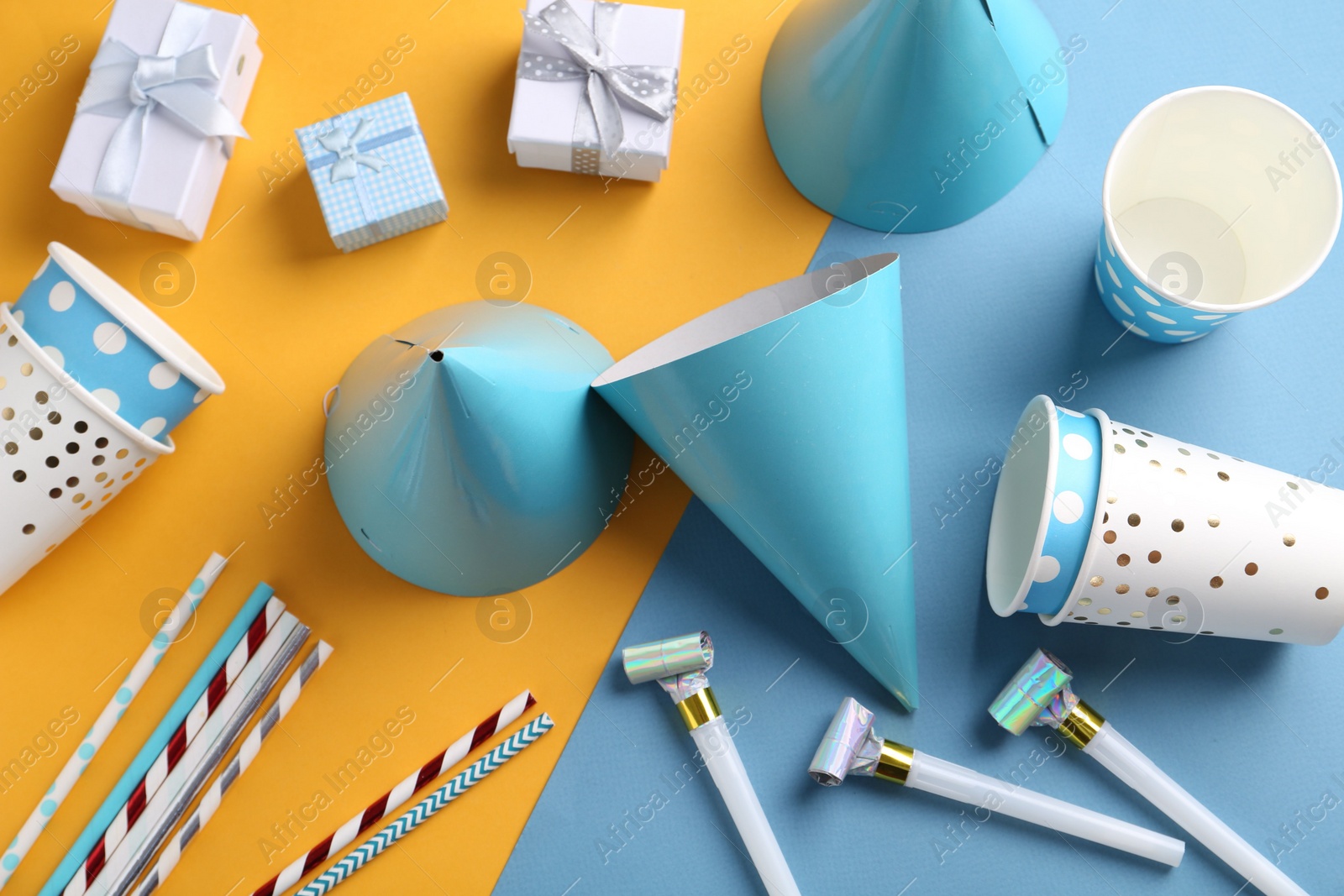 Photo of Party hats and other bright decor on color background, flat lay