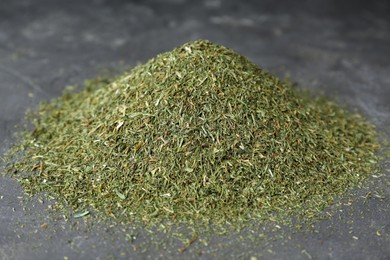 Photo of Pile of dried dill on grey table, closeup