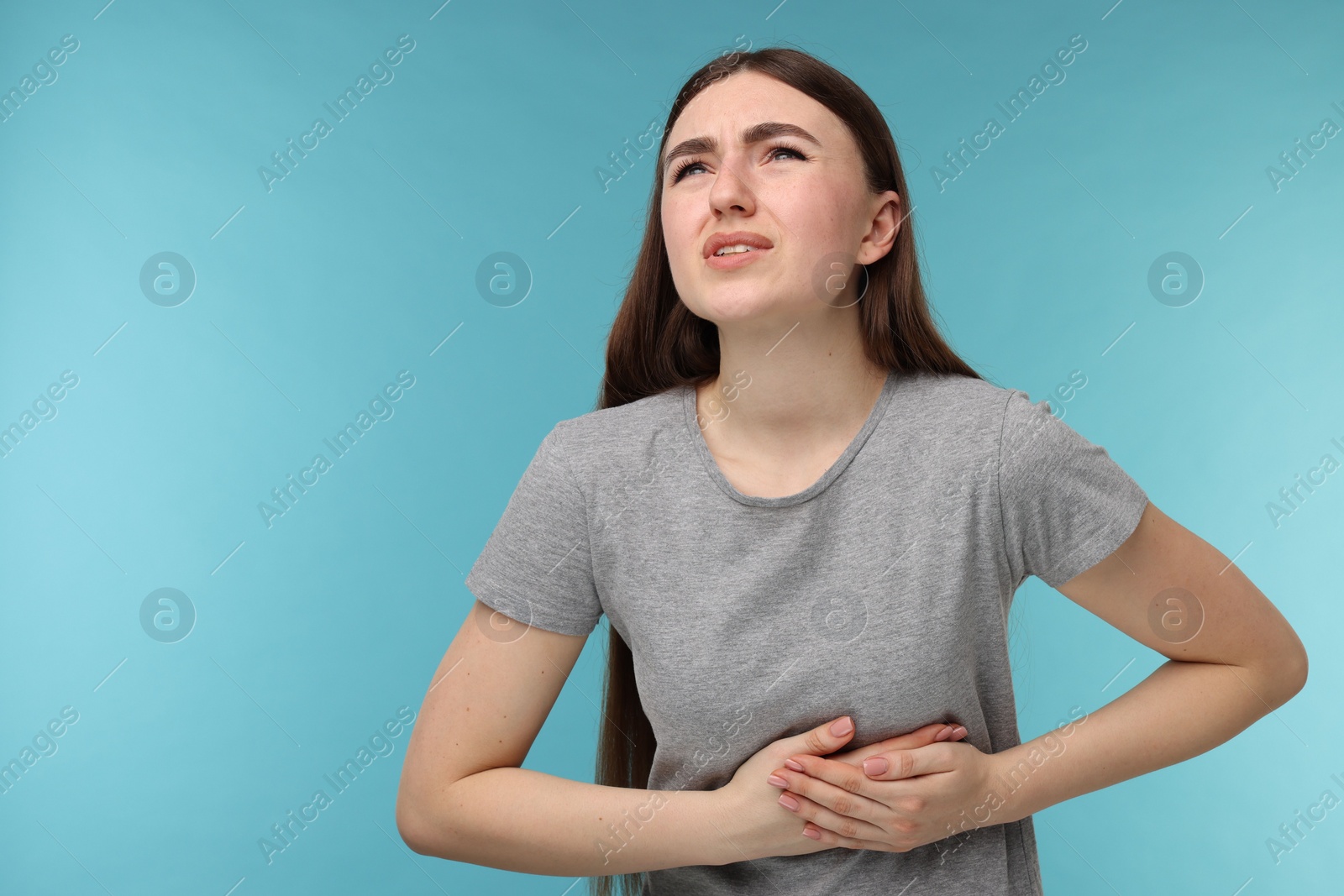 Photo of Woman having heart attack on light blue background