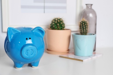 Photo of Color piggy bank on table in room. Cute interior element