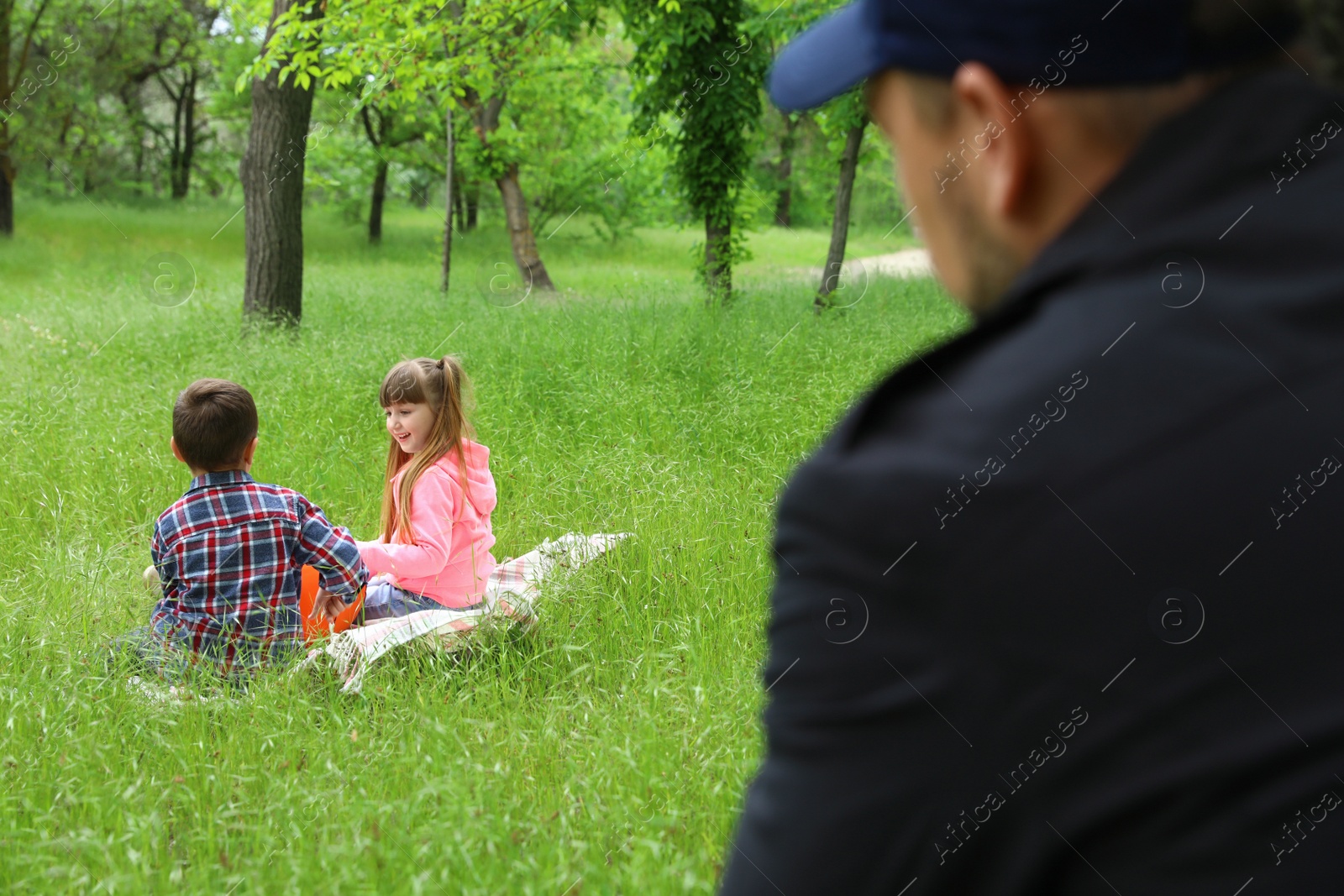Photo of Suspicious adult man spying on kids at park. Child in danger