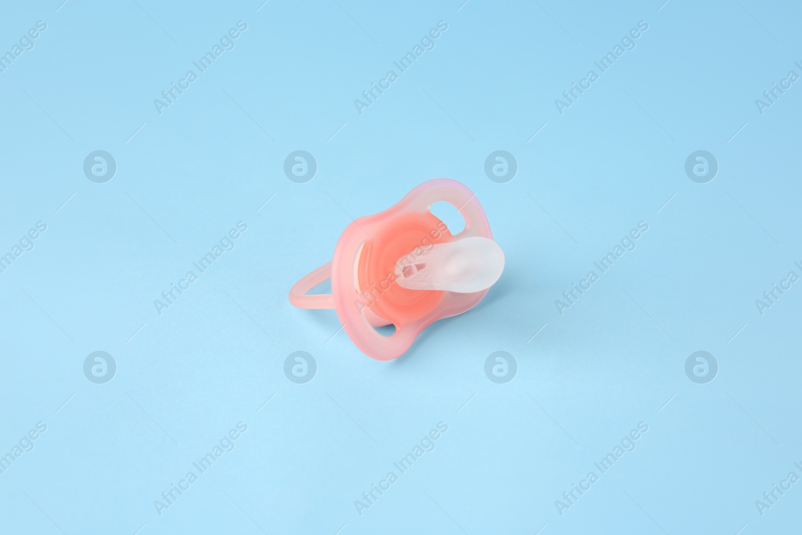 Photo of One new baby pacifier on light blue background