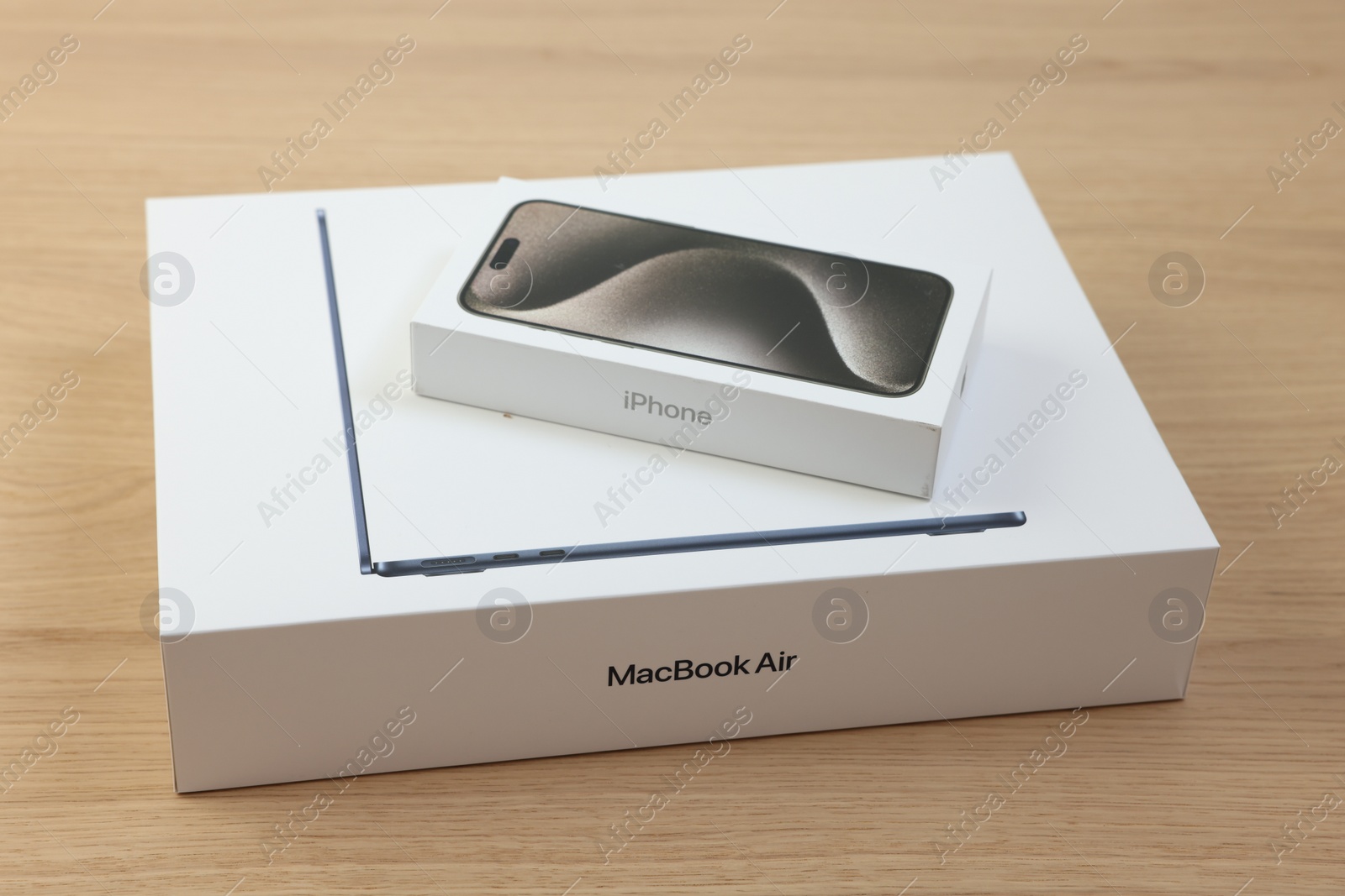 Photo of Leiden, Netherlands - October 6, 2023: Boxes with modern MacBook Air and iPhone 15 Pro Max on wooden table