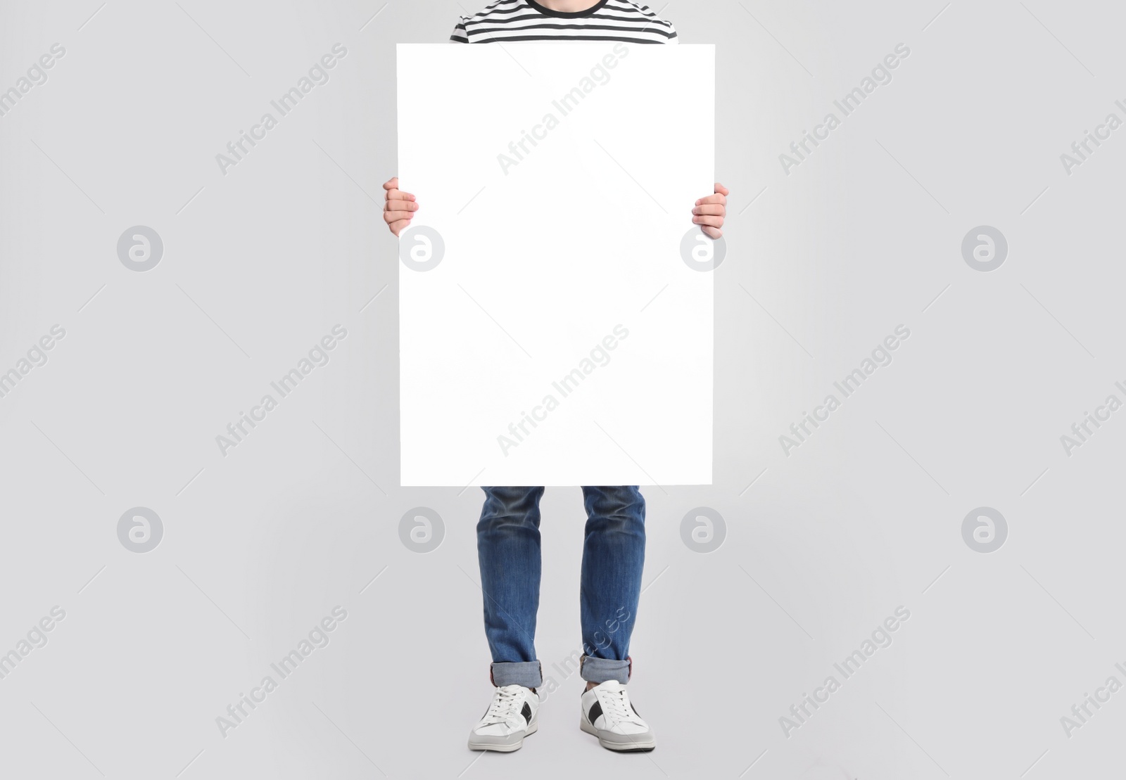 Photo of Man holding blank poster on light grey background, closeup