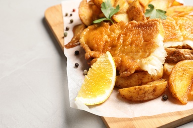 Photo of British traditional fish and potato chips on table, closeup with space for text