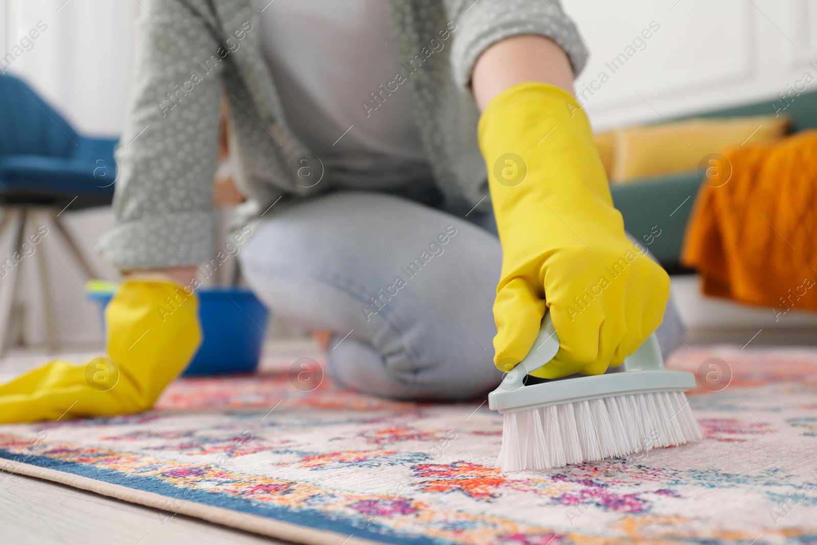 Photo of Woman cleaning carpet with brush indoors, closeup. Space for text