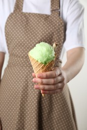 Photo of Woman holding waffle cone with cotton candy, closeup