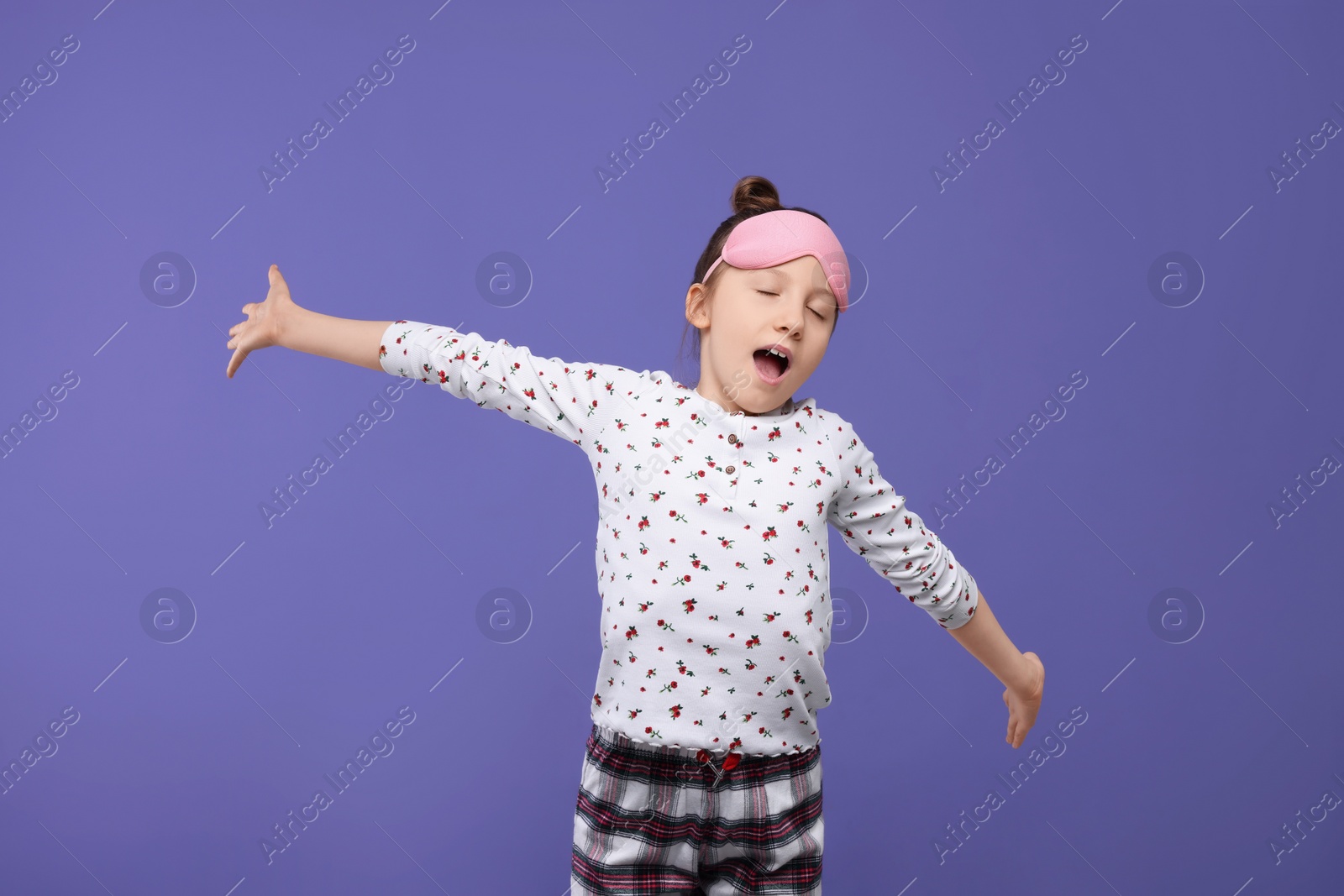 Photo of Girl with sleep mask yawning on purple background. Insomnia problem