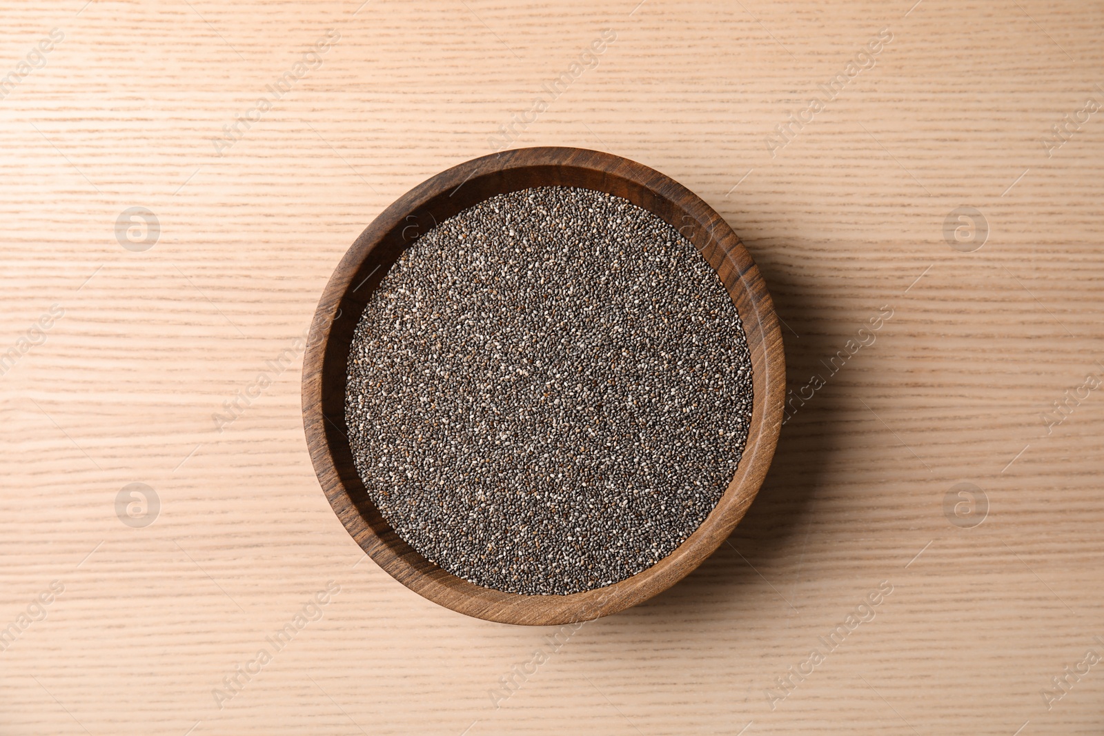 Photo of Bowl with chia seeds on wooden background, top view