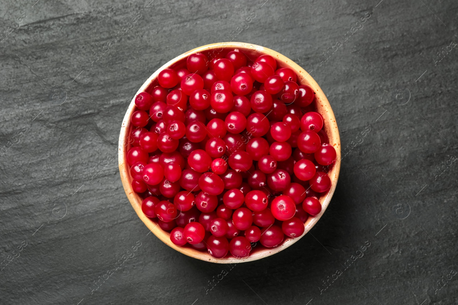 Photo of Tasty ripe cranberries on black table, top view