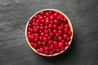 Photo of Tasty ripe cranberries on black table, top view