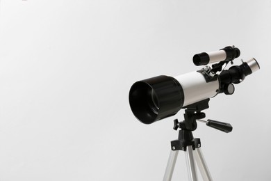 Tripod with modern telescope on light background, closeup. Space for text