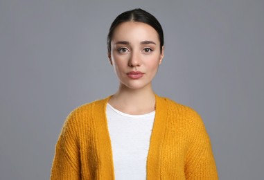 Portrait of beautiful young woman on grey background