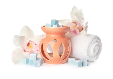 Photo of Stylish aroma lamp with essential wax cubes, flowers and towel on white background