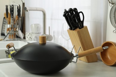 Photo of Wok pan and knife block on kitchen counter. Cooking utensils