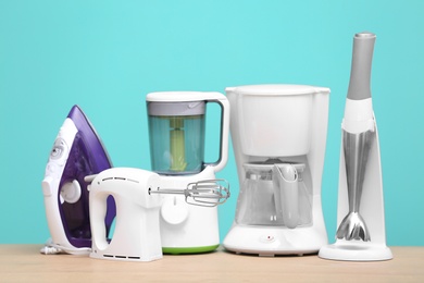 Photo of Household and kitchen appliances on table against color background. Interior element