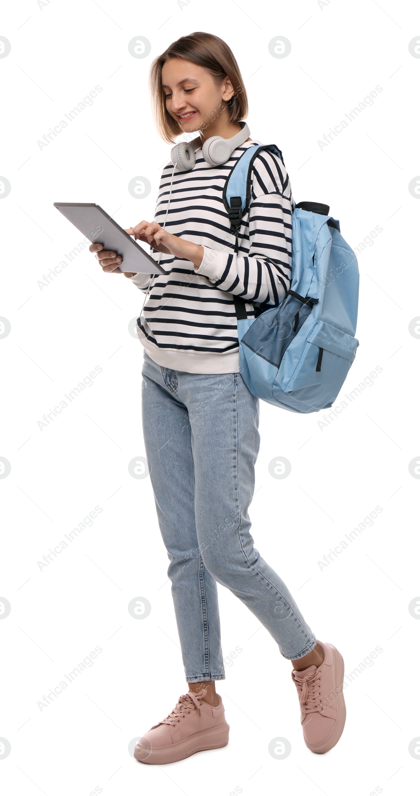 Photo of Young student with tablet, backpack and headphones on white background