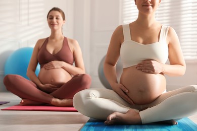Photo of Group of pregnant women practicing yoga in gym, closeup