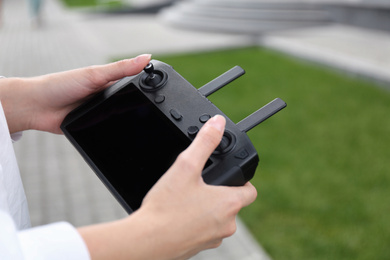 Photo of Woman with modern drone controller outdoors, closeup