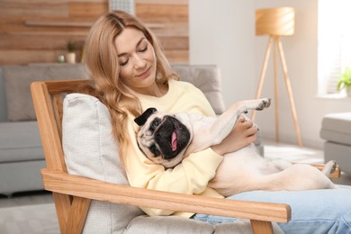 Photo of Woman with cute pug dog at home. Animal adoption