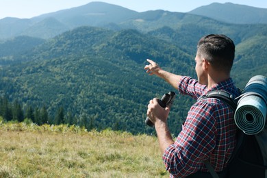 Photo of Tourist with hiking equipment and binoculars in mountains