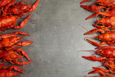 Delicious boiled crayfishes on grey table, flat lay. Space for text