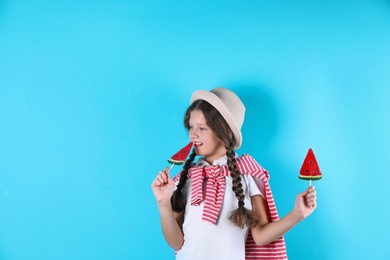 Photo of Little girl with candies on color background