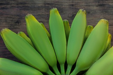 Photo of Bunch of delicious bananas on wooden table, closeup