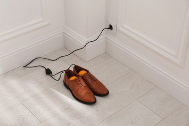 Shoes with electric dryer on floor indoors