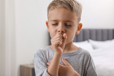Photo of Sick boy coughing at home. Cold symptoms