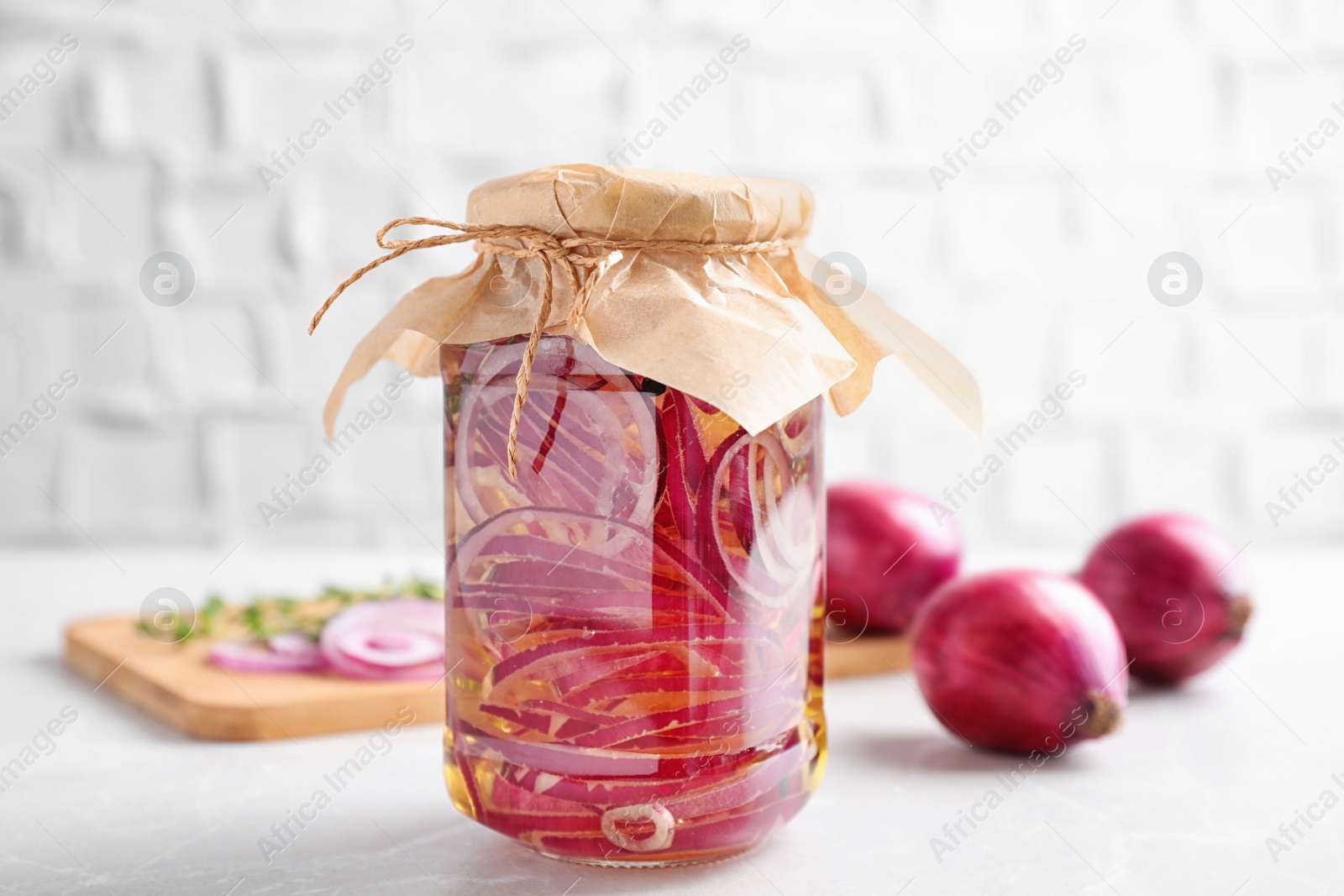 Photo of Jar of pickled onions on white table