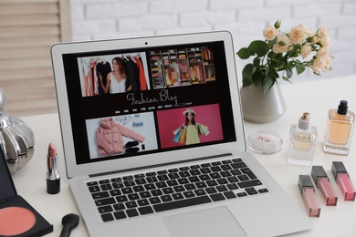 Photo of Laptop with open fashion blogger site on table