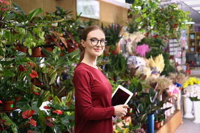 Photo of Female business owner with tablet in flower shop
