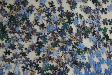 Photo of Jigsaw puzzle pieces on white table, flat lay