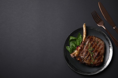 Photo of Flat lay composition with grilled meat steak on black background. Space for text