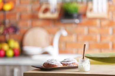 Jar with coconut oil and tasty pastry on table in kitchen. Healthy cooking