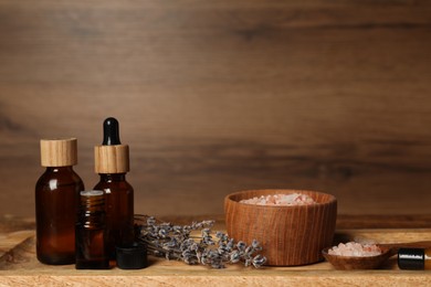 Photo of Different aromatherapy products and lavender on wooden table