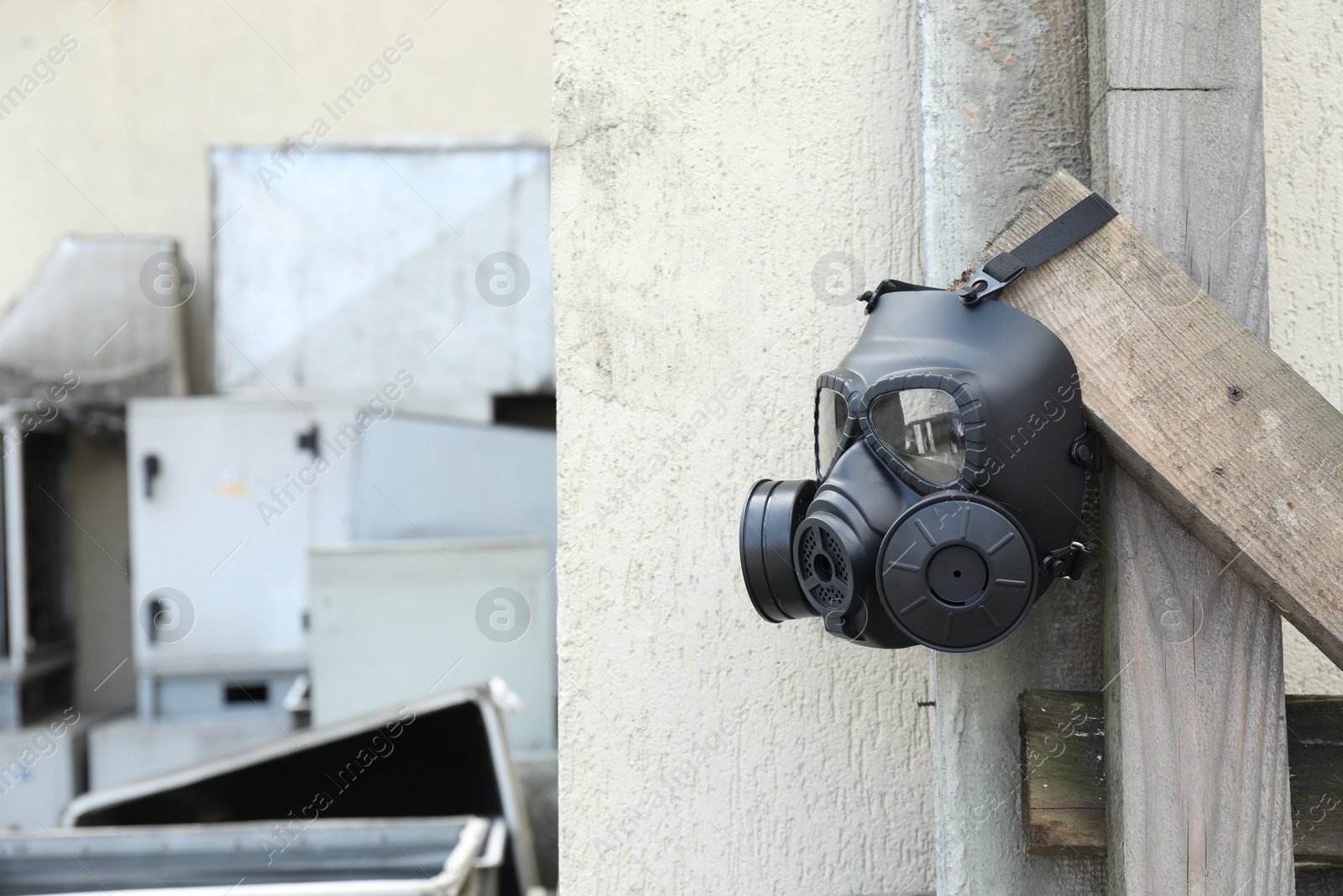 Photo of One gas mask hanging on building outdoors. Space for text