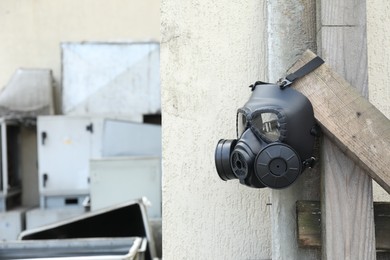 One gas mask hanging on building outdoors. Space for text