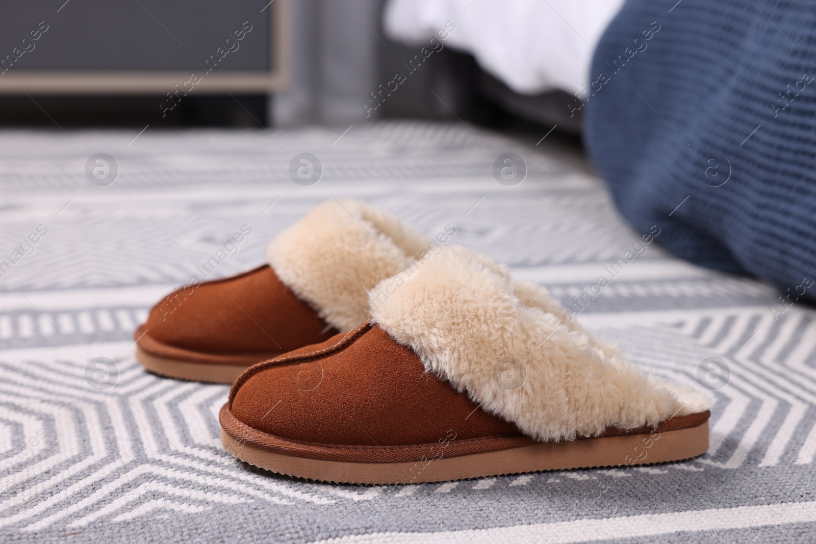 Photo of Brown soft slippers on carpet indoors, closeup