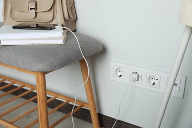 Photo of Electric power outlet sockets with charger on white wall