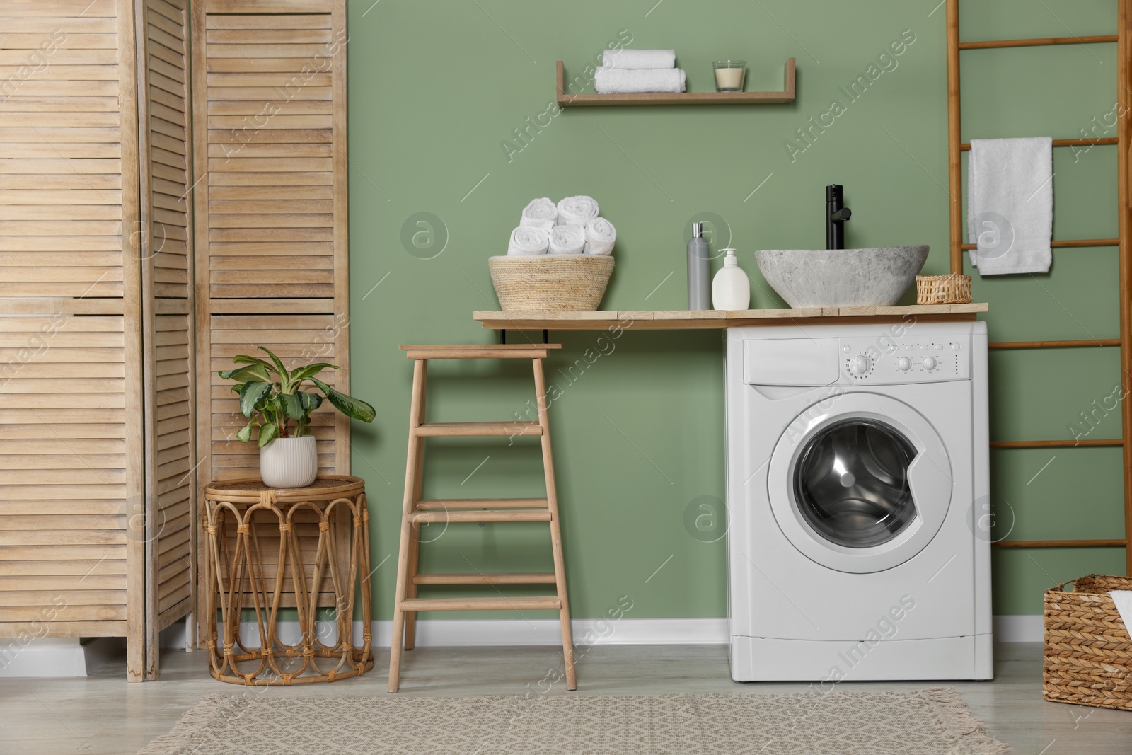 Photo of Stylish laundry room with functional washing machine. Interior design