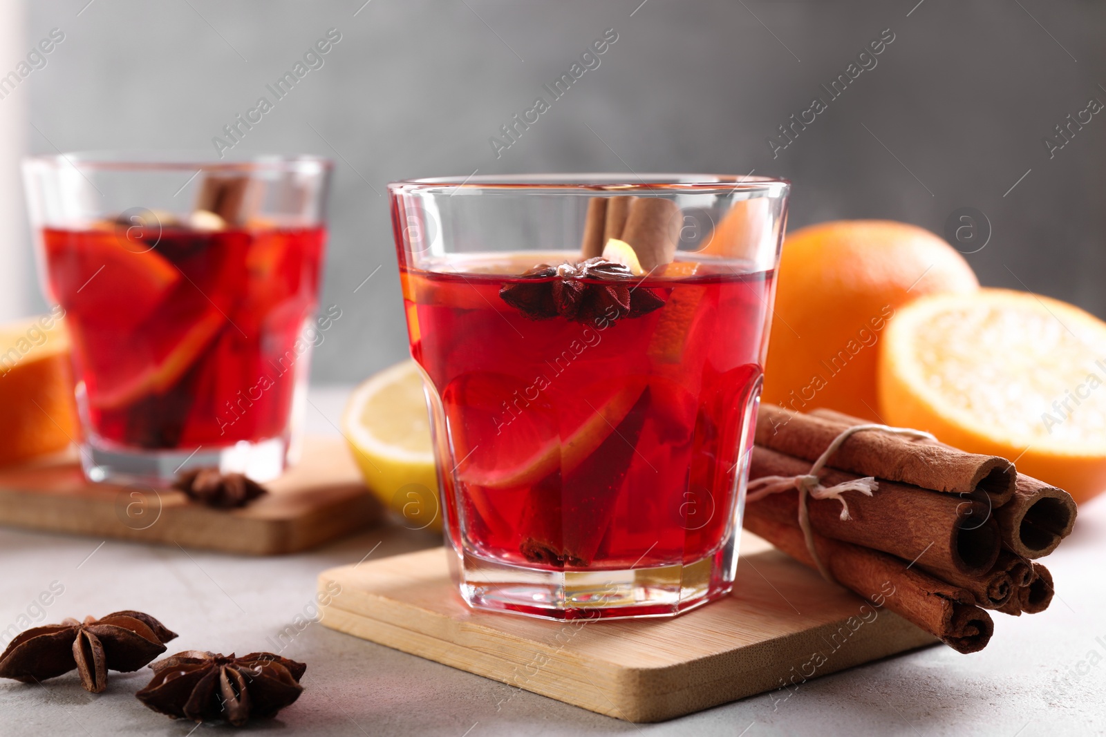 Photo of Aromatic punch drink and ingredients on white table