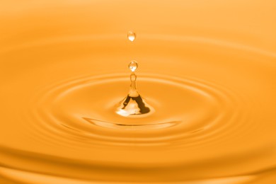 Splash of water with drop, closeup. Toned in orange