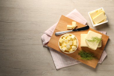 Tasty butter with dill and knife on wooden table, flat lay. Space for text