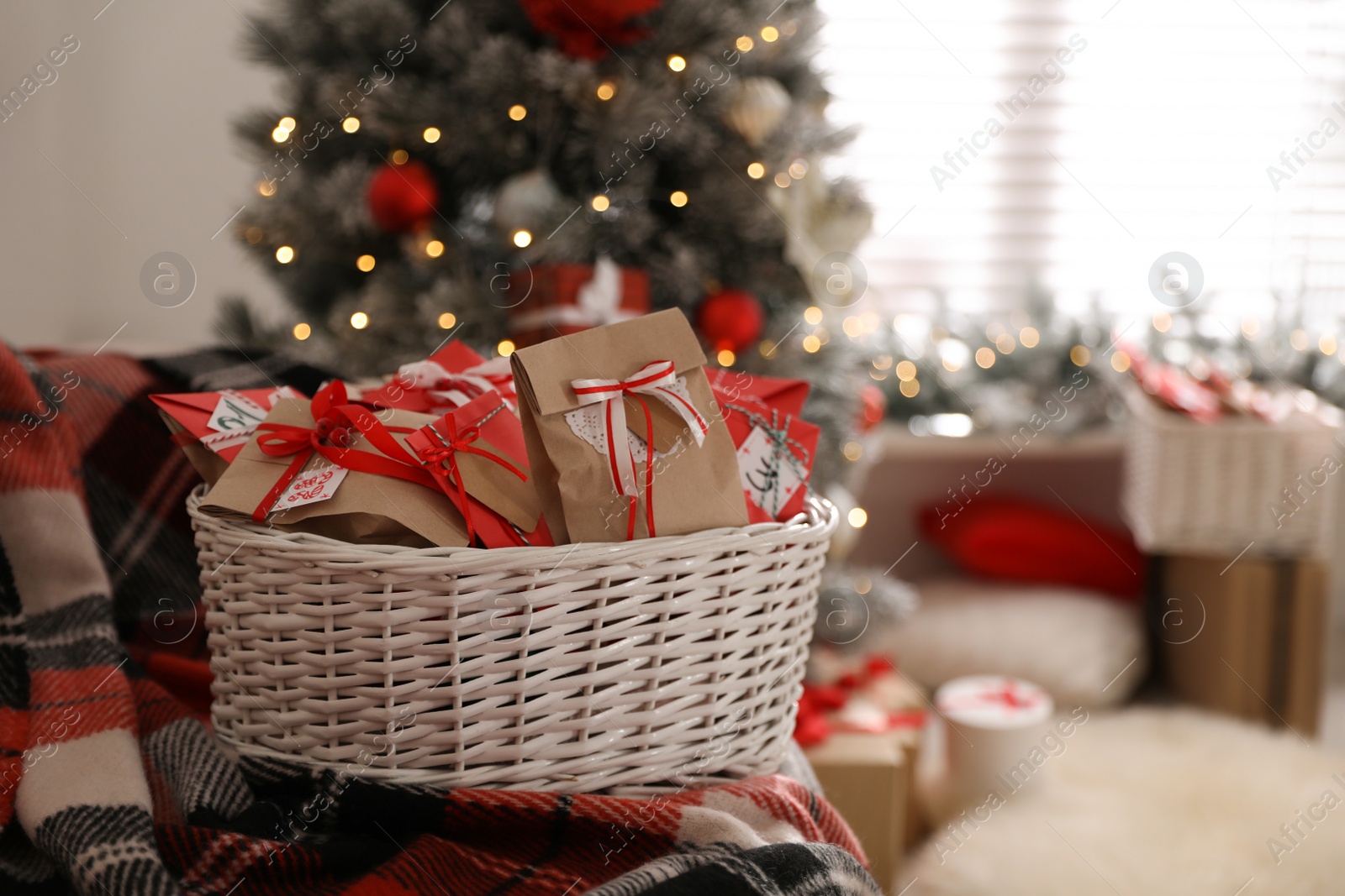 Photo of Basket full of gifts in paper bags for Christmas advent calendar at home, space for text