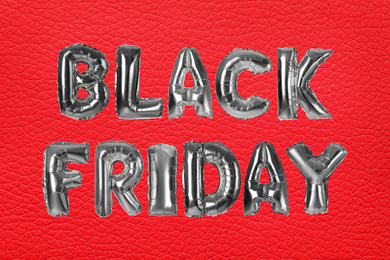 Phrase BLACK FRIDAY made of foil balloon letters on red background