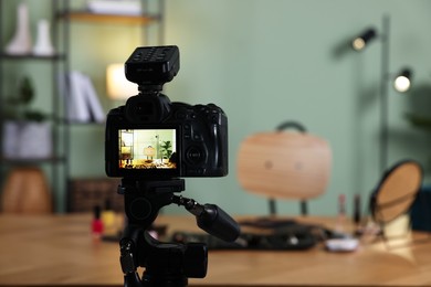 Photo of Beauty blogger's workplace. Cosmetic products on table indoors, focus on camera