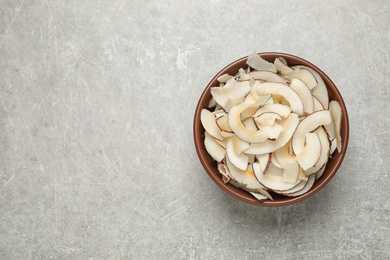 Photo of Tasty coconut chips on grey table, top view. Space for text