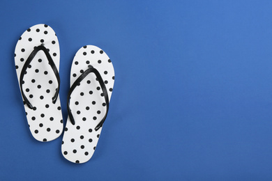 Photo of Stylish flip flops on blue background, flat lay. Space for text